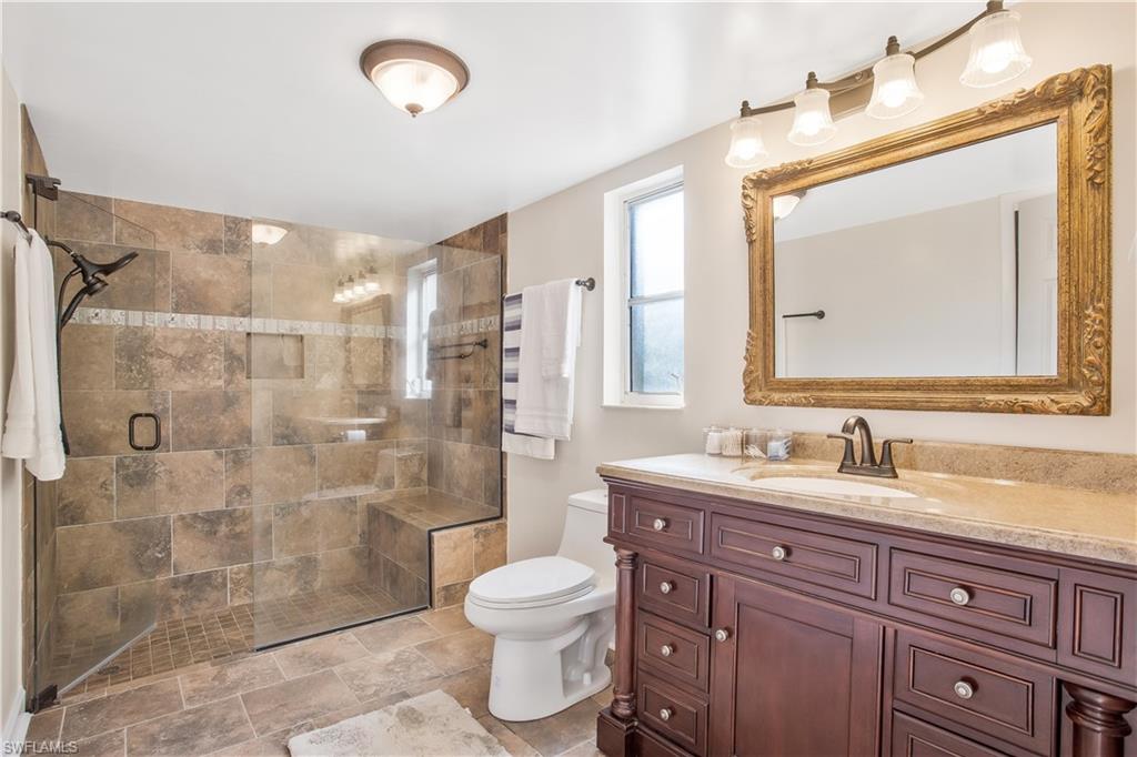 1039 Cardinal Street Naples, FL 34104 - Photo 20 of 29 a bathroom with a toilet sink and mirror
