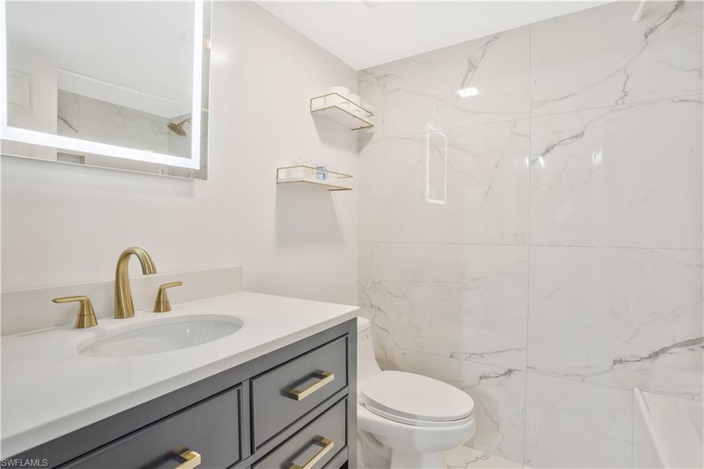 1039 Cardinal Street Naples, FL 34104 - Photo 21 of 29 a bathroom with a sink a toilet and shower