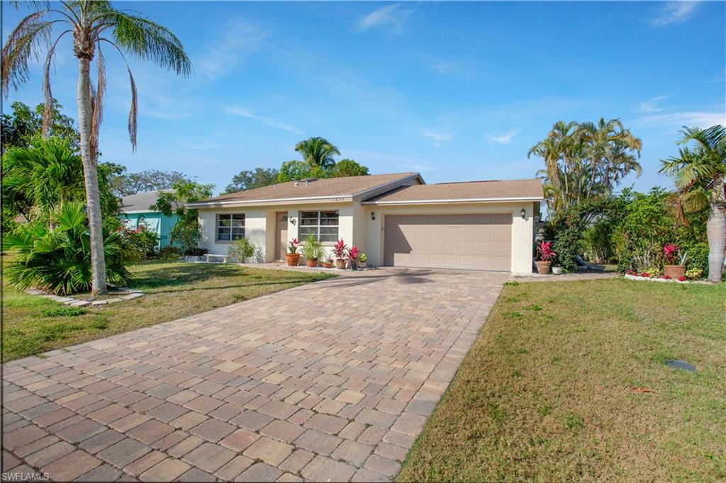 1039 Cardinal Street Naples, FL 34104 - Photo 27 of 29 a view of a white house with a yard and potted plants
