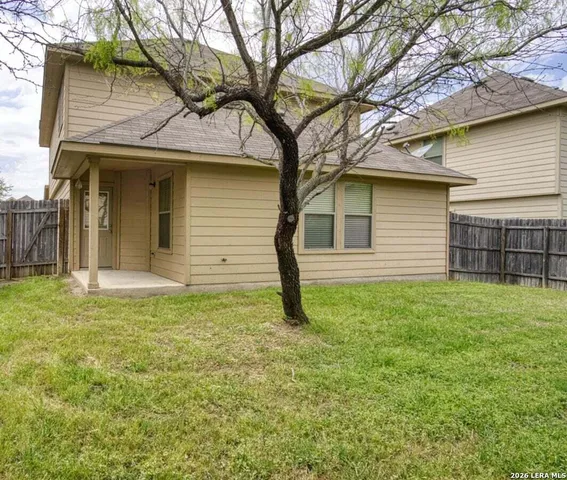 a house that has a tree in front of a house