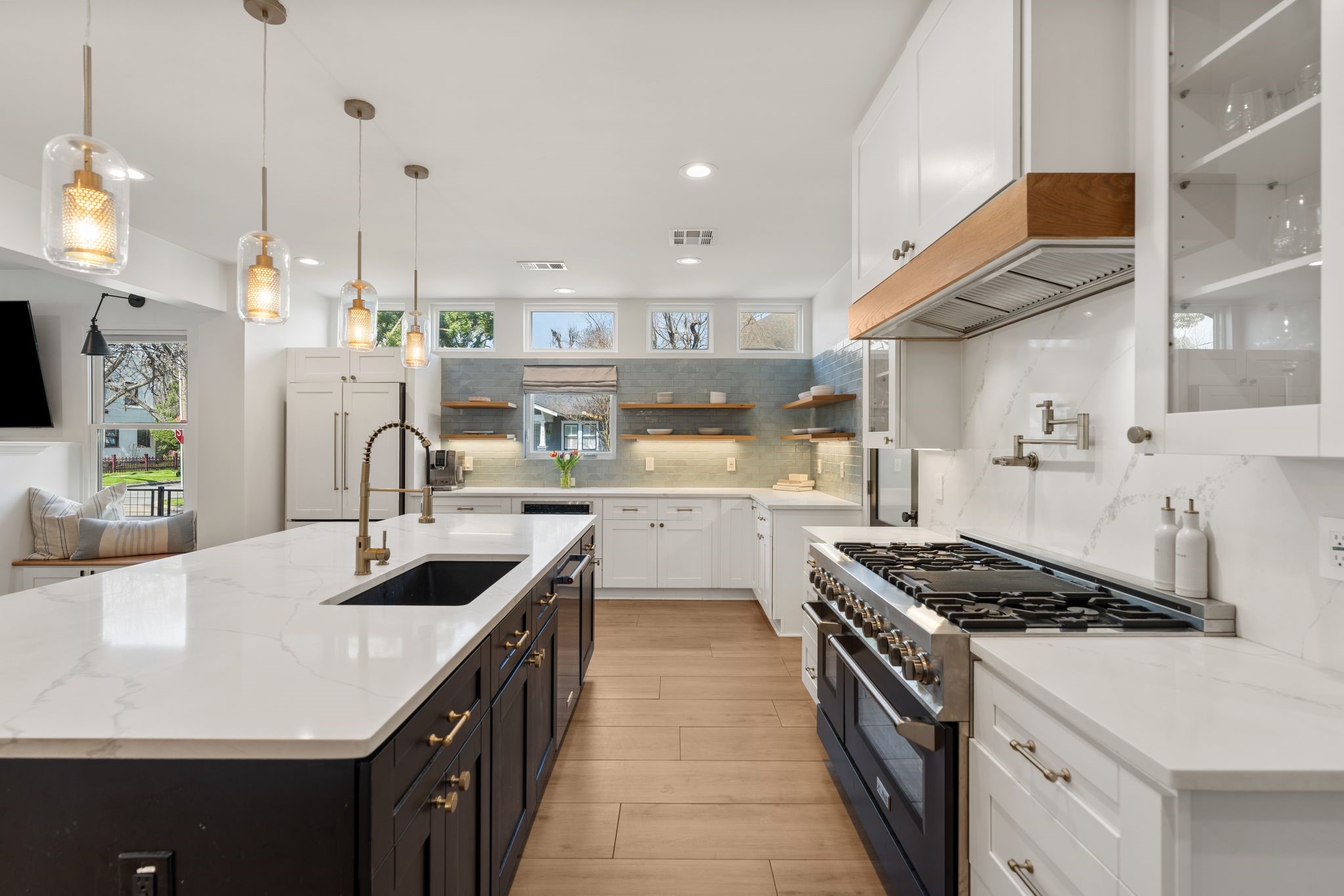 2626 Reagan Street Houston, TX 77009 - Photo 11 of 50 The kitchen is equipped with a professional grade z-line glass range with 6 gas burners + griddle, 2 ovens, vent hood and pot filler. Note: Sellers have stainless steel fronts that came from manufacturer should new owner want to change it. The kitchen is also equipped with a built in microwave and KitchenAid dishwasher. The quartz countertops were taken up the backsplash and glass front display cabinetry provides a place to showcase dishware. The adjacent wall features a designer blue tile backsplash with
