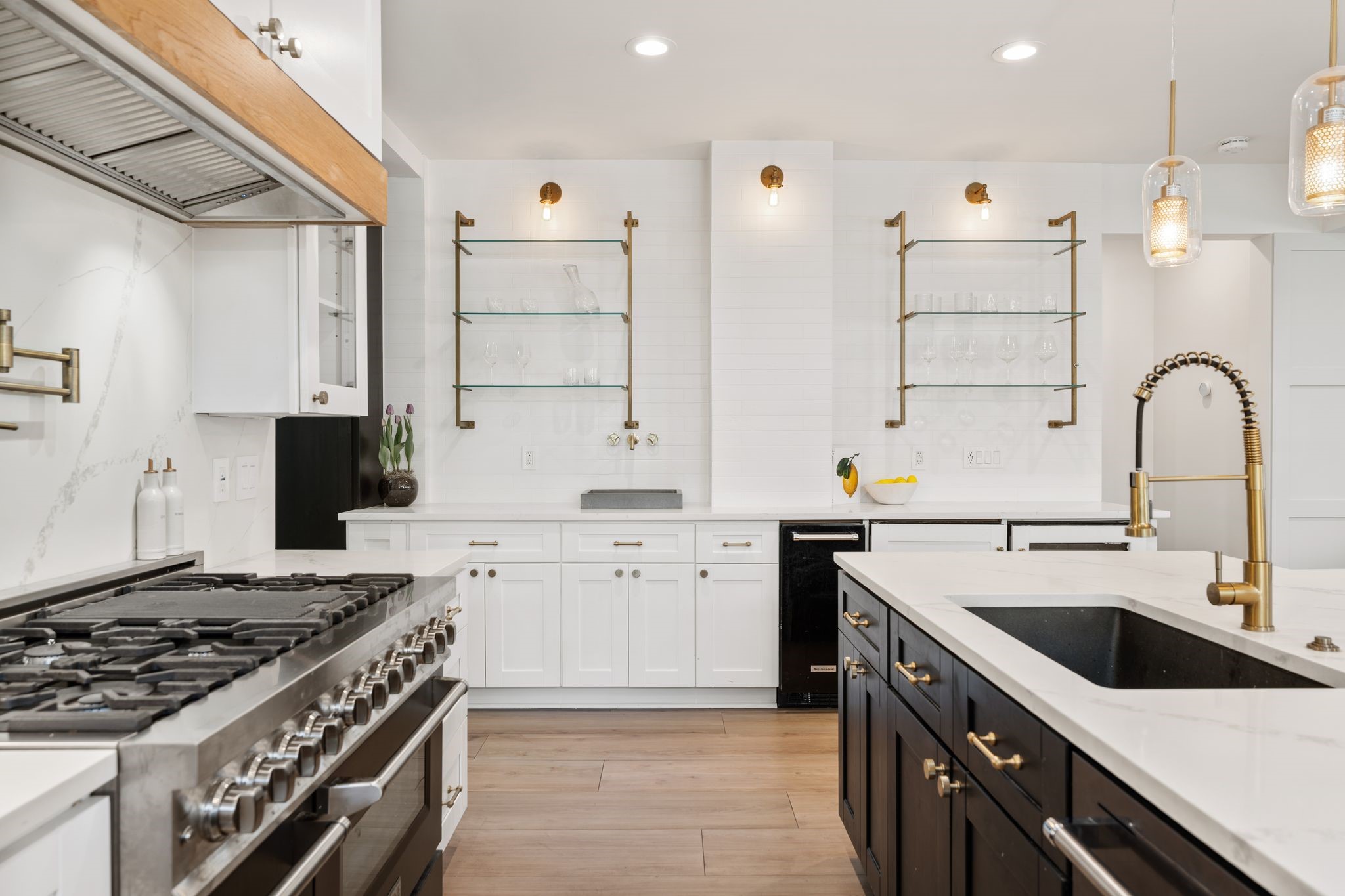 2626 Reagan Street Houston, TX 77009 - Photo 12 of 50 Located just off of the kitchen, the wet bar features quartz countertops, custom cabinetry, open glass shelving with decorative lighting, a beverage refrigerator and wine fridge creating a convenient space for serving drinks and entertaining.