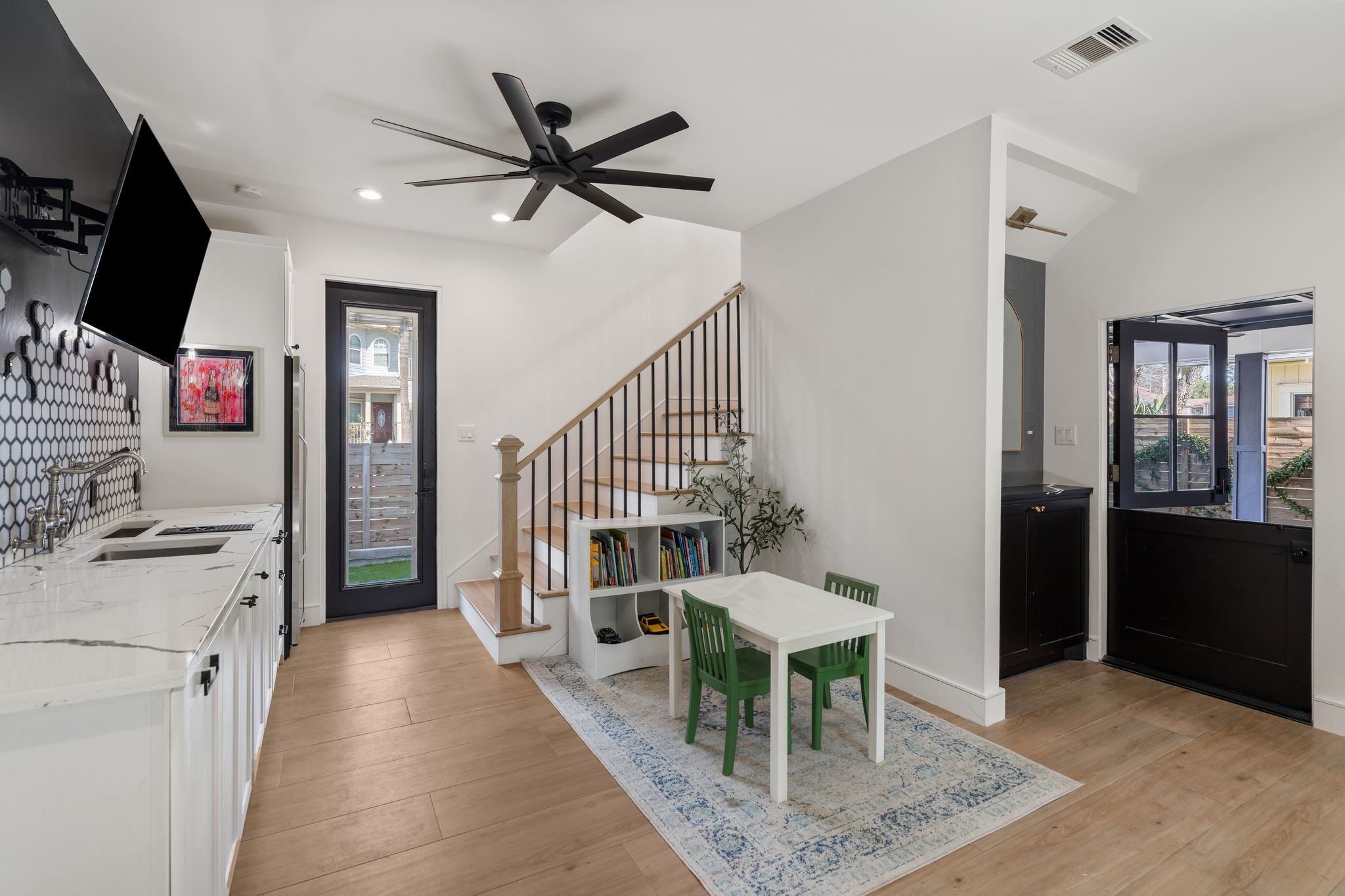 2626 Reagan Street Houston, TX 77009 - Photo 15 of 50 Located just inside from the backyard this versatile space works well as a playroom, game room, or secondary living area.There is also a dutch door providing access to the attached carport and a door to the attached garage. The built in wet bar is a perfect place to entertain as you are watching the game and grilling just outside in the built in outdoor kitchen. There is also a full size stainless steel wine fridge.