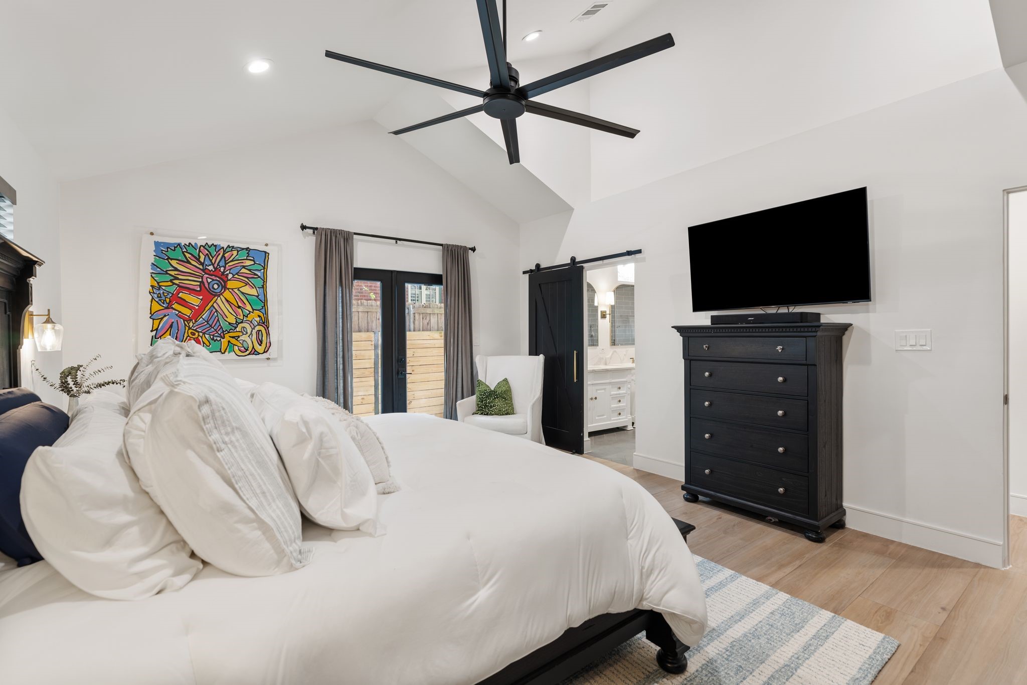 2626 Reagan Street Houston, TX 77009 - Photo 19 of 50 Another view of the spacious primary bedroom highlights the vaulted ceiling and open layout, with direct access to the primary bathroom just off of the sleeping area.