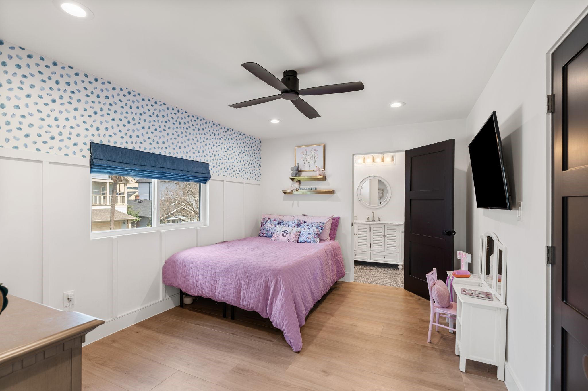 2626 Reagan Street Houston, TX 77009 - Photo 32 of 50 Charming upstairs secondary bedroom #3 features decorative accent wallpaper, wainscoting detail, recessed lighting, and a modern ceiling fan. The room also includes a large window with custom blackout shades and a walk in closet.