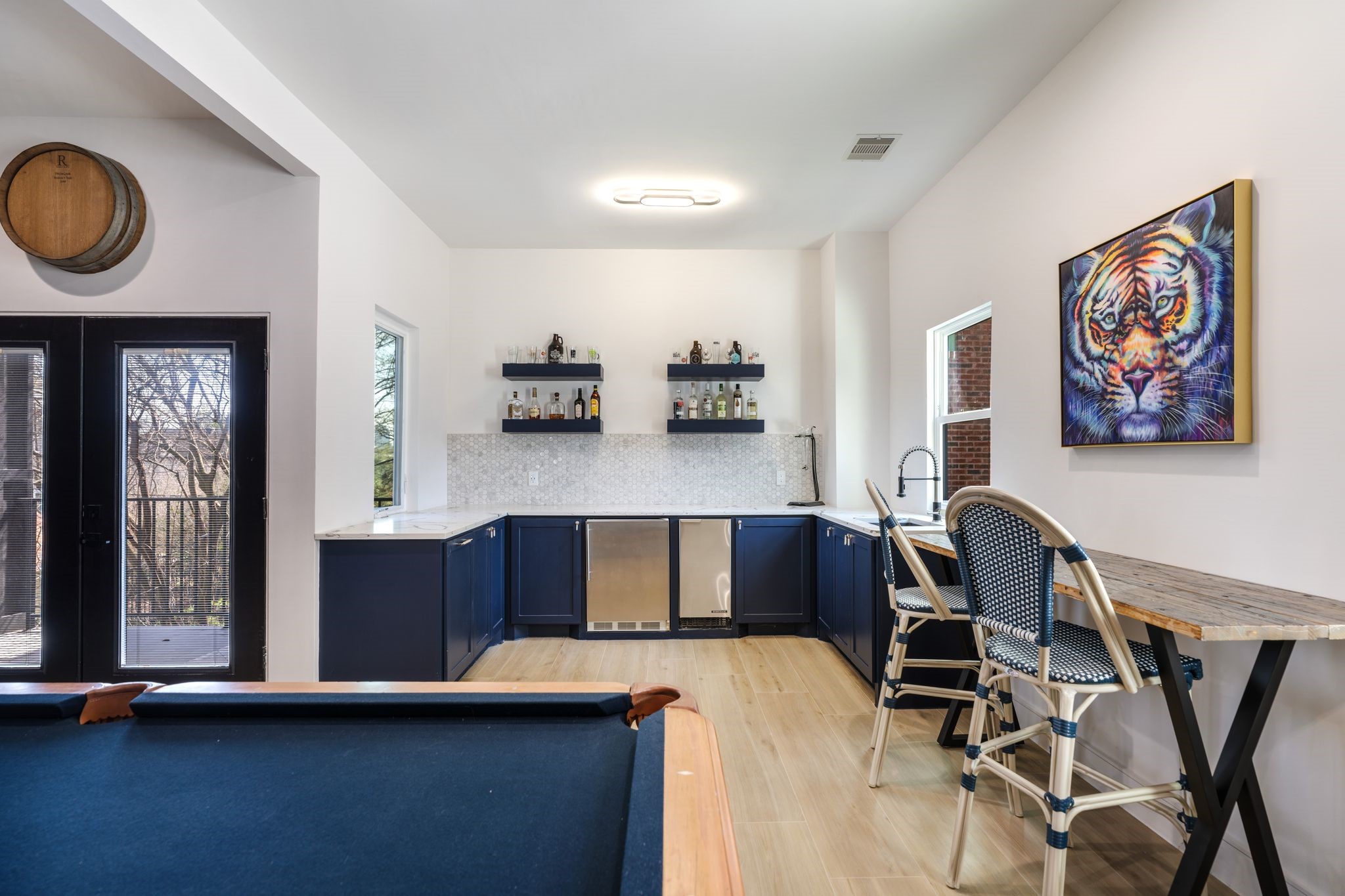 2626 Reagan Street Houston, TX 77009 - Photo 37 of 50 The game room also includes a built-in wet bar with quartz countertops, a marble hexagon tile backsplash, ice maker, beverage fridge, and floating shelves for display and storage, creating the perfect setup for hosting friends and family. The space also offers direct access to a private outdoor balcony and includes a conveniently located dedicated half bath. There is a 240V should someone wish to add a range.