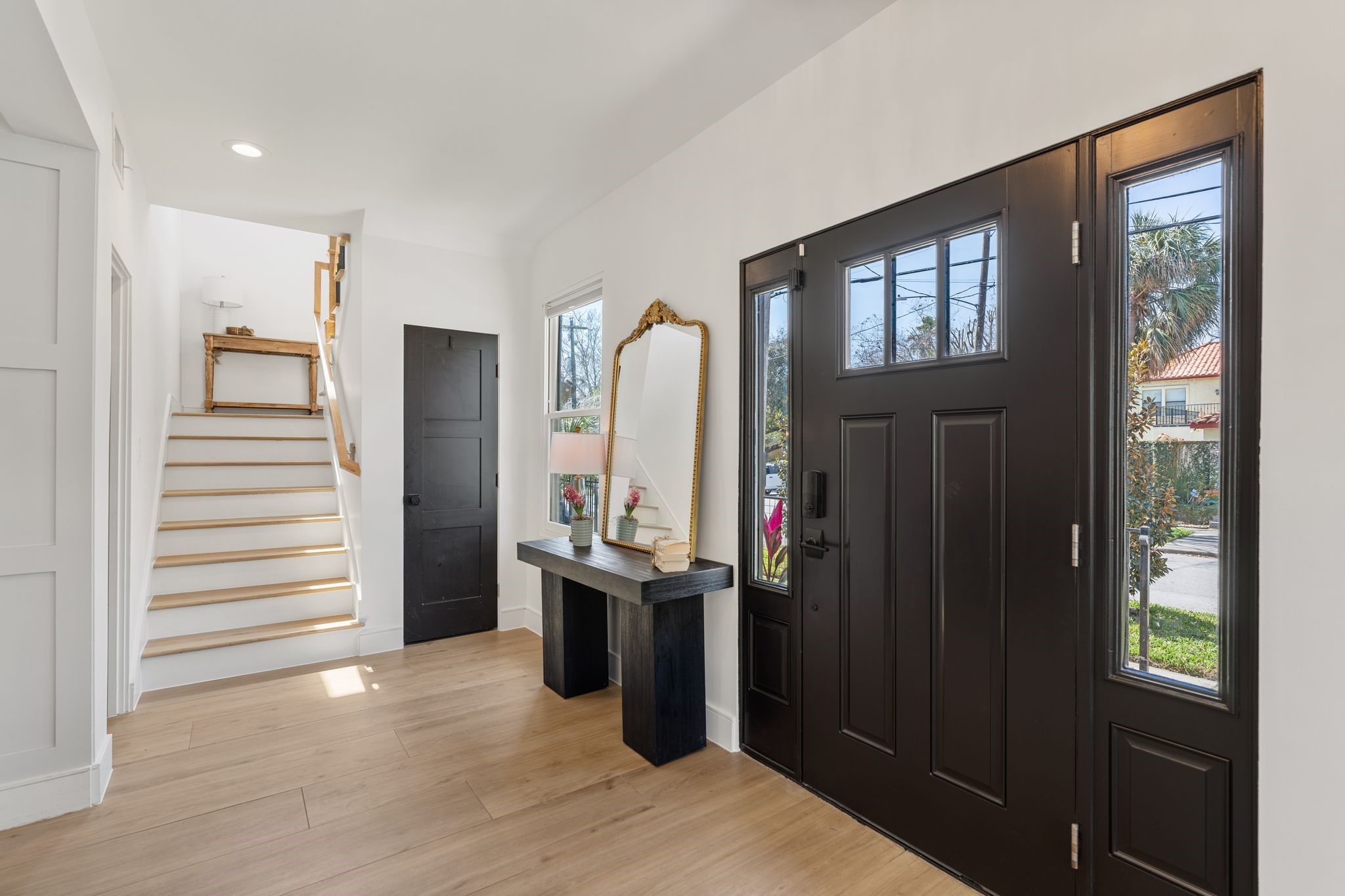 2626 Reagan Street Houston, TX 77009 - Photo 4 of 50 The foyer offers a bright and welcoming entry into the home. There are two sets of stairs in the home plus an additional set from the garage for the guest suite. The door shown in the photo provides access to a storage closet located beneath the staircase, while the powder bath is located just to the left at the base of the stairs.
