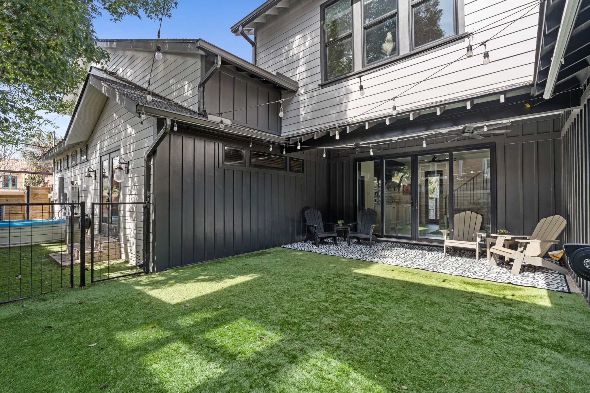 2626 Reagan Street Houston, TX 77009 - Photo 42 of 50 The backyard offers a spacious turf lawn and covered patio where sliding glass doors fully open to create seamless indoor-outdoor living, allowing the interior living space to flow effortlessly outside and making this area ideal for entertaining guests or hosting gatherings, while still leaving ample room for future additions such as a pool.