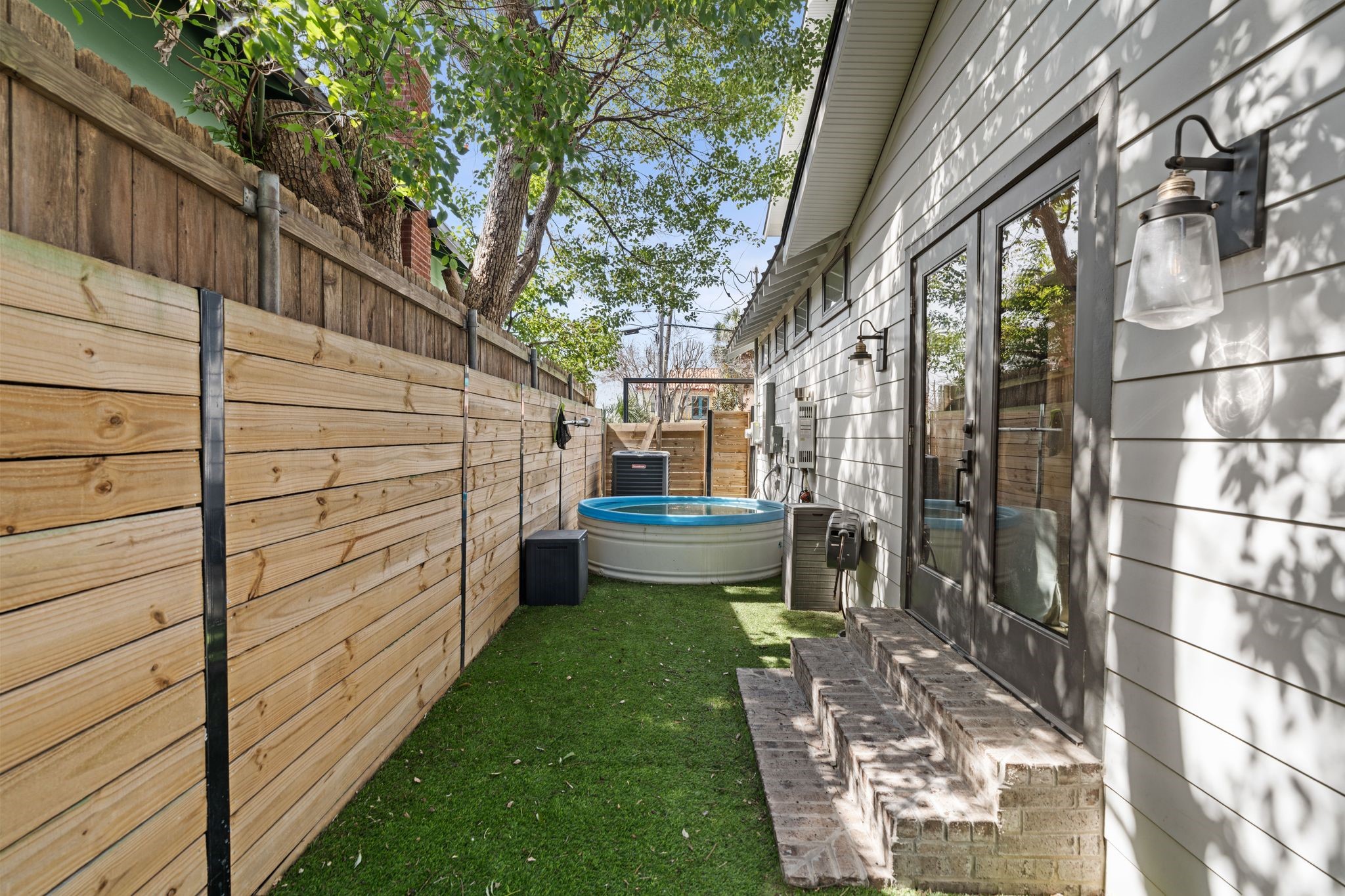 2626 Reagan Street Houston, TX 77009 - Photo 44 of 50 The side yard sits just off the primary suite, where the double glass doors provide direct access from the bedroom to a private outdoor retreat, offering a quiet space to step outside and enjoy fresh air or relax just steps from the primary bedroom.