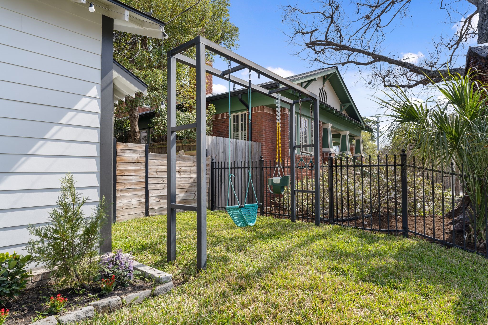 2626 Reagan Street Houston, TX 77009 - Photo 46 of 50 Located along the side of the home, this yard area features a swing set and additional fenced outdoor space, providing a great spot for kids to play or enjoying extra yard space.