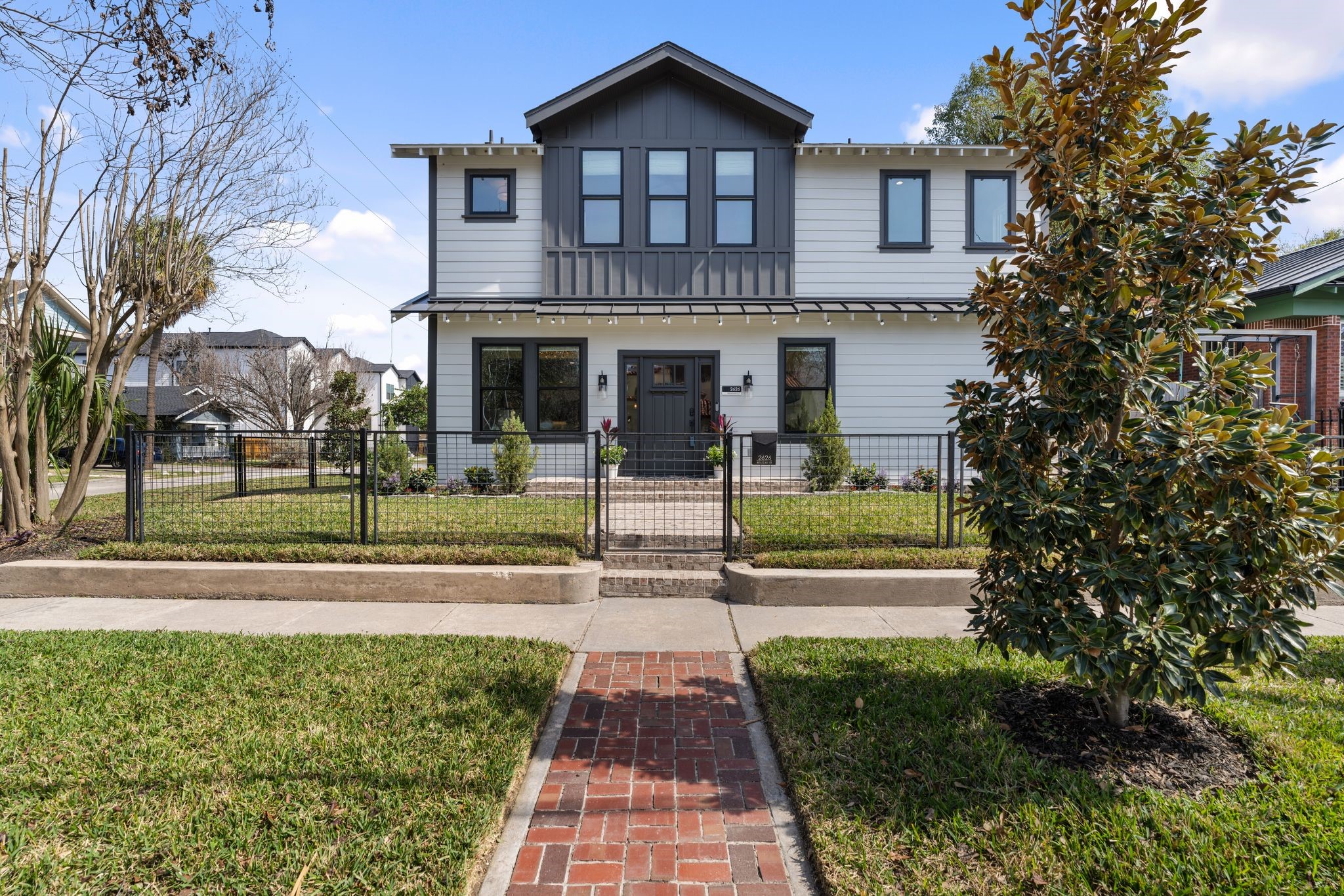 2626 Reagan Street Houston, TX 77009 - Photo 49 of 50 Another front exterior view of the home highlighting the charming brick walkway that leads to the front door, along with the fully fenced front yard that provides a perfect place for kids to play and a welcoming outdoor space while enhancing the home's curb appeal.
