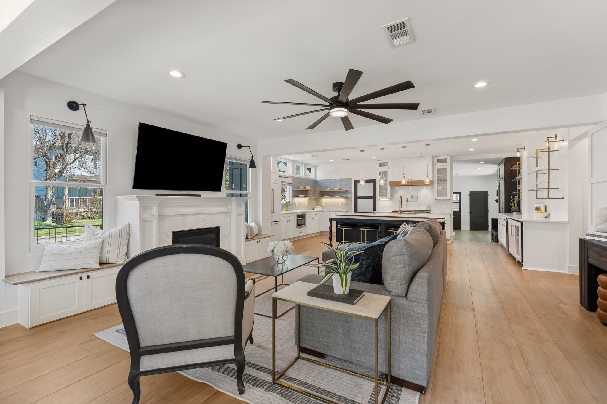 2626 Reagan Street Houston, TX 77009 - Photo 6 of 50 All new and large windows installed in 2026 bring an abundant natural light while overlooking the yard. Built-in window seating with storage flanks each side of the fireplace, while decorative lights above the windows adds additional character to the space.