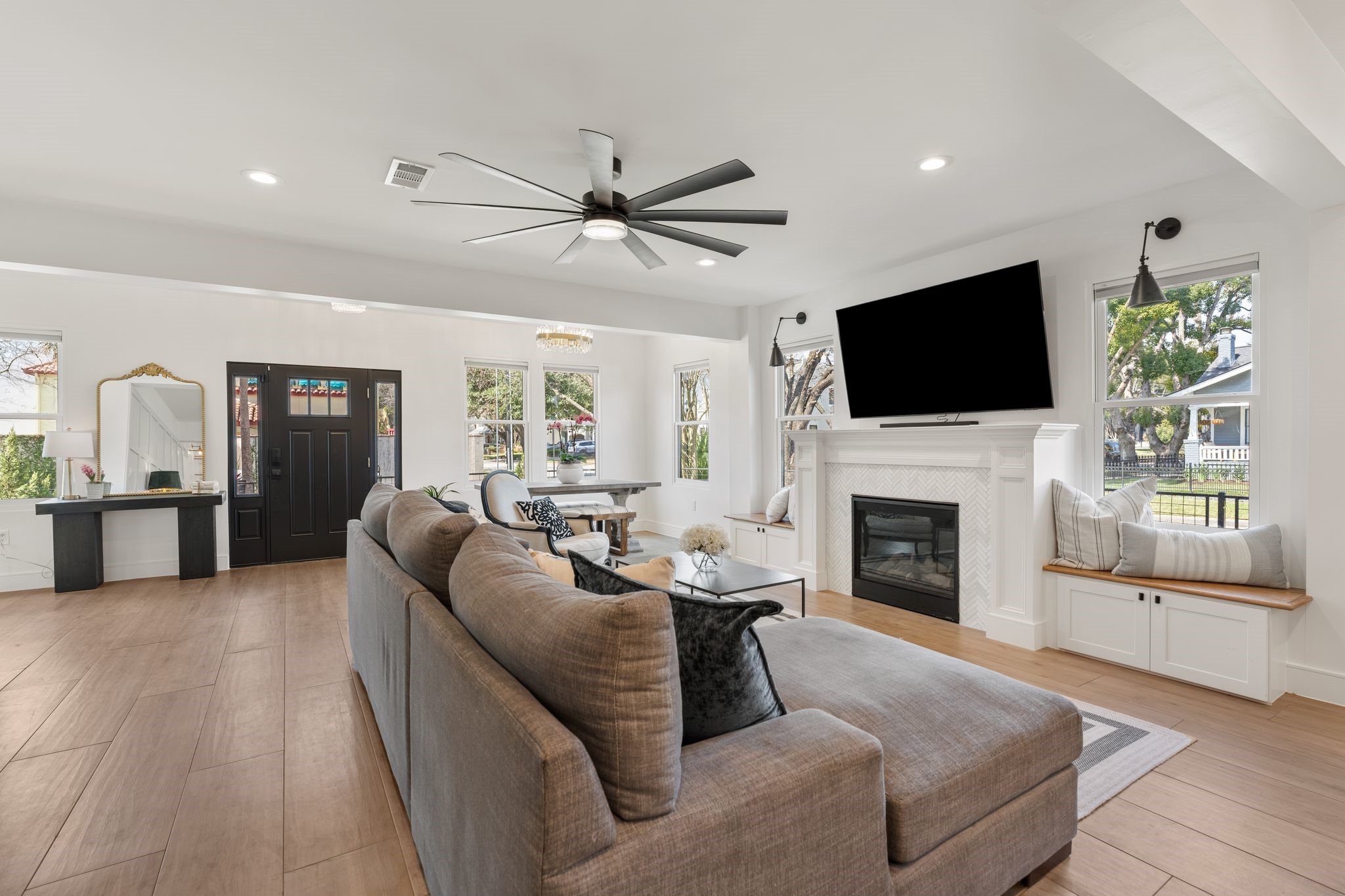2626 Reagan Street Houston, TX 77009 - Photo 7 of 50 The family room features a gas fireplace with elegant surround, new herringbone tile detail (2026), and a custom mantle with decorative millwork creating a beautiful focal point within the living space.