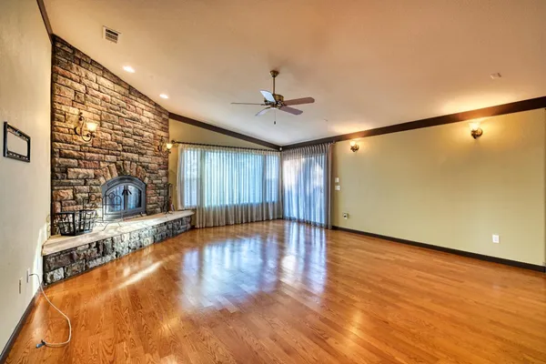 a view of empty room with wooden floor and fireplace