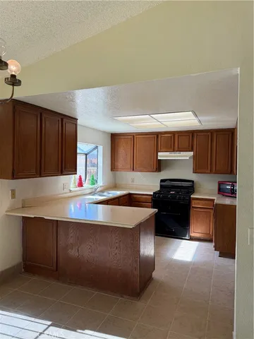 a kitchen with granite countertop a sink cabinets and stainless steel appliances
