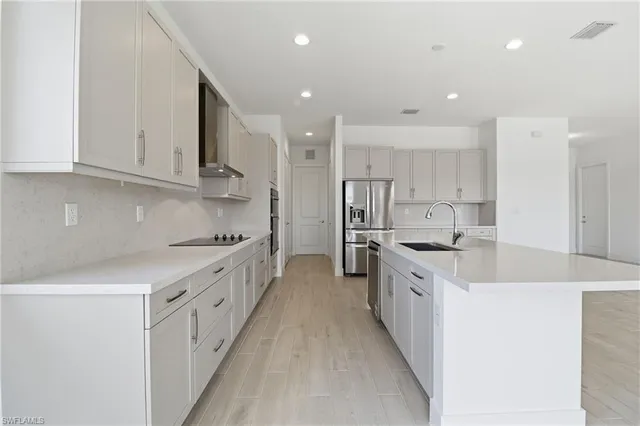a large kitchen with stainless steel appliances granite countertop a lot of counter space and a sink