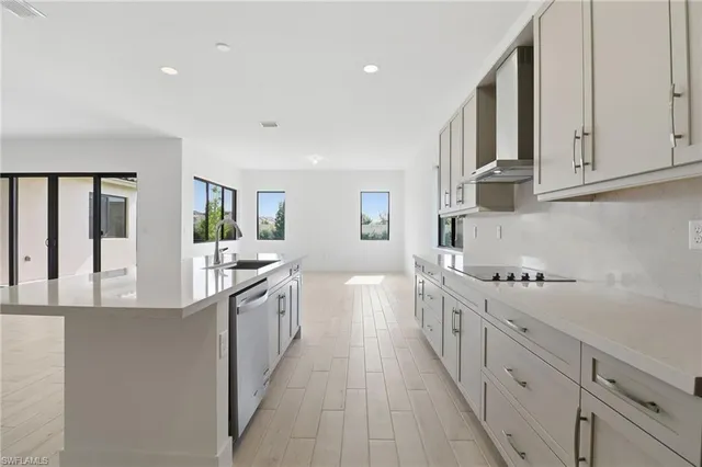 a kitchen with white cabinets and sink