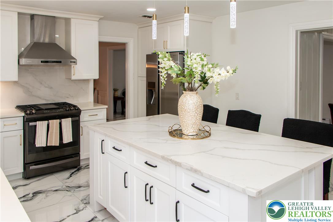 3582 Country Club Road Easton, PA 18045 - Photo 4 of 48 A well-appointed kitchen showcasing a spacious island with ample seating and elegant pendant lighting.
