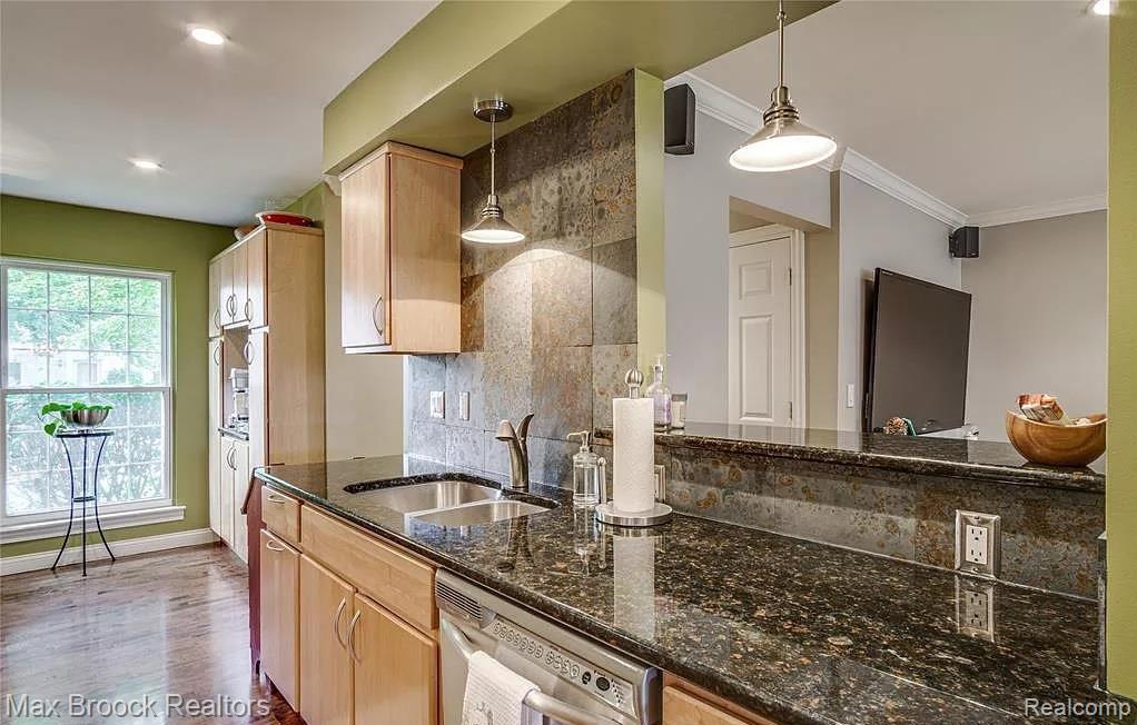126 Manor Way Rochester, MI 48309 - Photo 14 of 31 Kitchen featuring wood-finish cabinetry, dark speckled countertops, stone-look tile backsplash, stainless steel sink, and recessed lighting