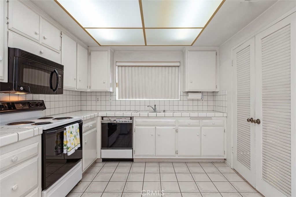 5081 Blackpool Road Westminster, CA 92683 - Photo 16 of 45 a kitchen with white cabinets appliances and sink