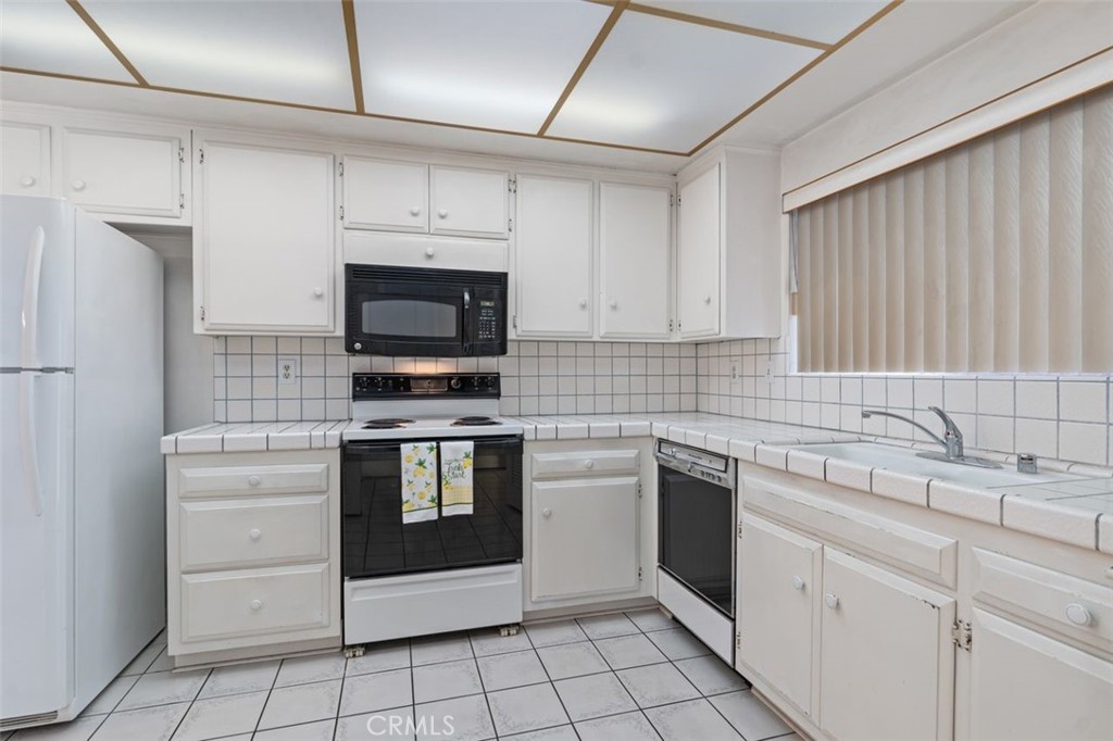 5081 Blackpool Road Westminster, CA 92683 - Photo 18 of 45 a kitchen with white cabinets stainless steel appliances and a sink