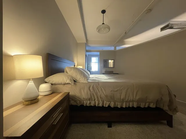 a bedroom with a bed and a large window