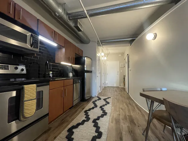 a kitchen with stainless steel appliances granite countertop a stove a sink and a refrigerator