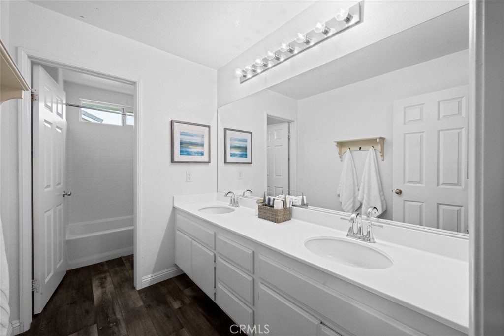 7220 Cumberland Place Rancho Cucamonga, CA 91739 - Photo 30 of 41 Hall bathroom featuring a dual-sink vanity and vinyl plank flooring.