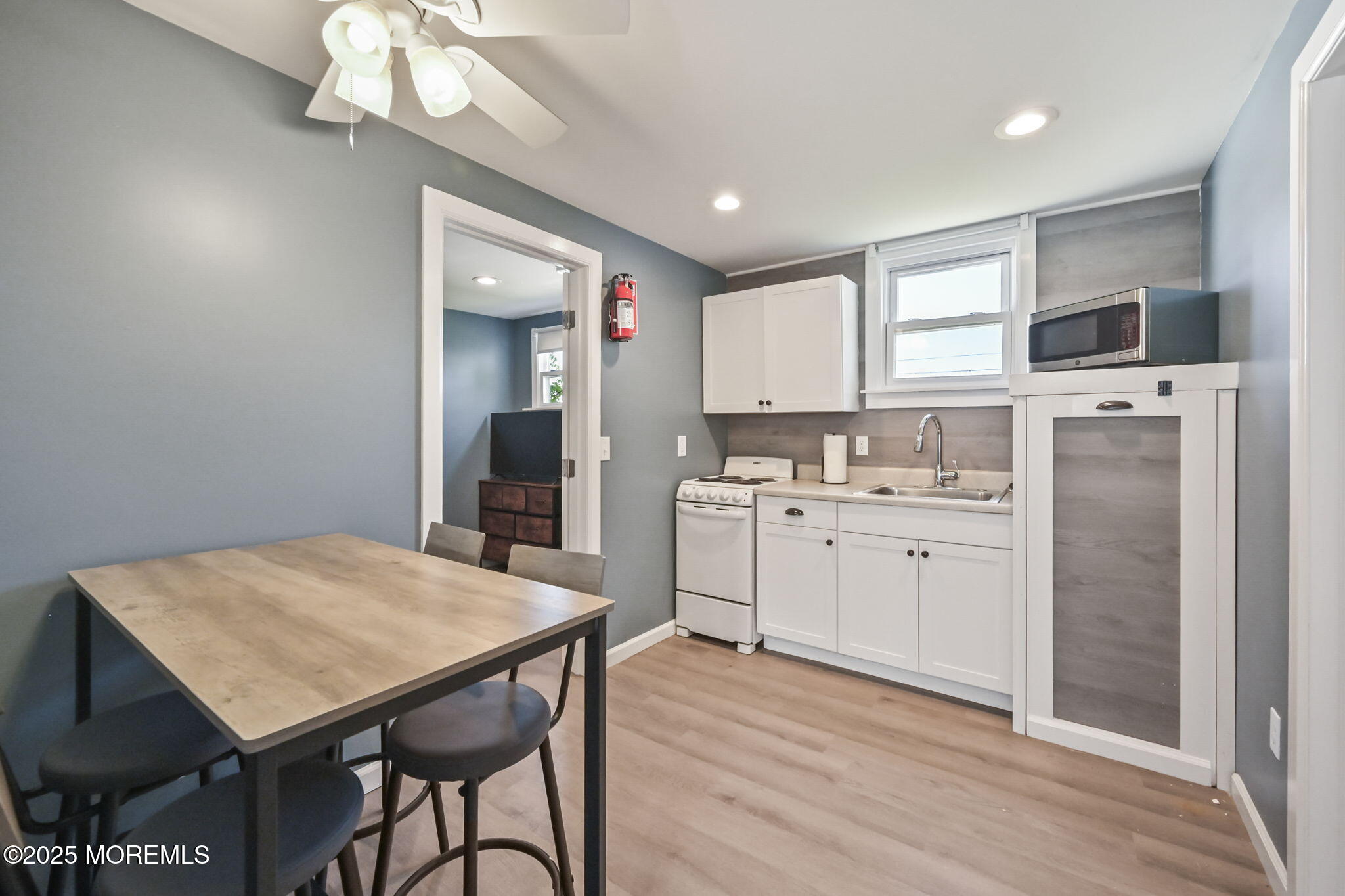 206 16th Avenue Belmar, NJ 07719 - Photo 13 of 20 a kitchen with a table chairs refrigerator and cabinets