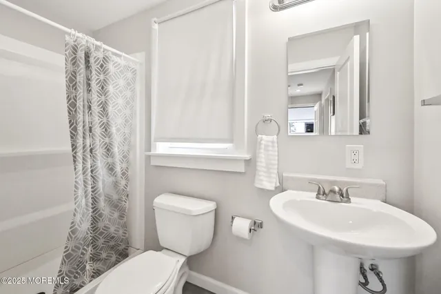 a bathroom with a sink toilet and a mirror