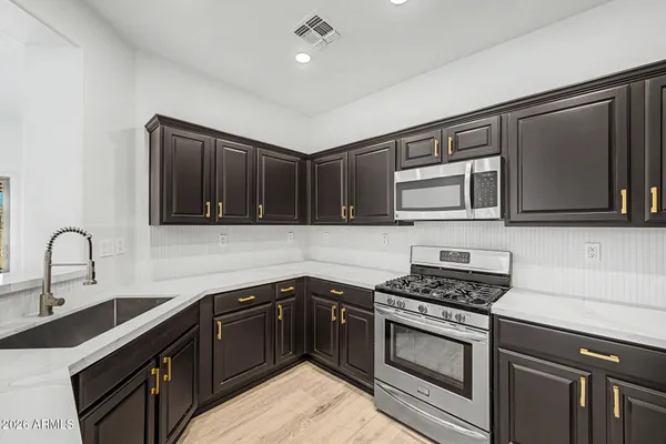 a kitchen with stainless steel appliances granite countertop a stove a sink dishwasher and a microwave