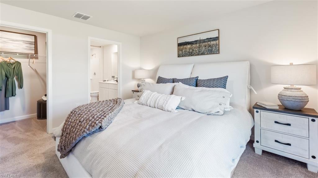 3913 16th Street West Lehigh Acres, FL 33971 - Photo 12 of 15 Model home. Bedroom with light carpet, a closet, and connected bathroom