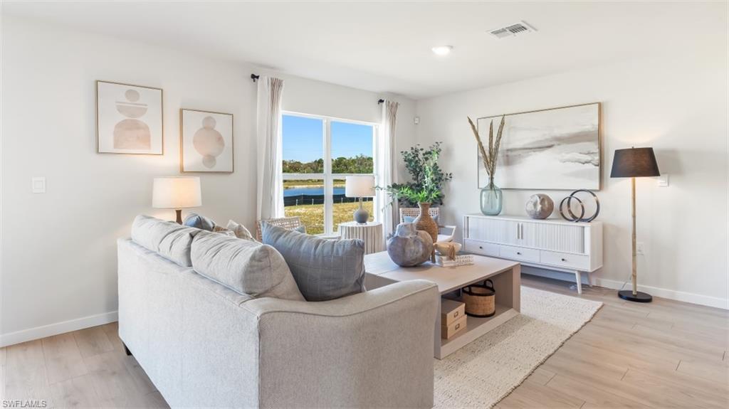 3913 16th Street West Lehigh Acres, FL 33971 - Photo 3 of 15 Model home. Living room featuring light wood-type flooring