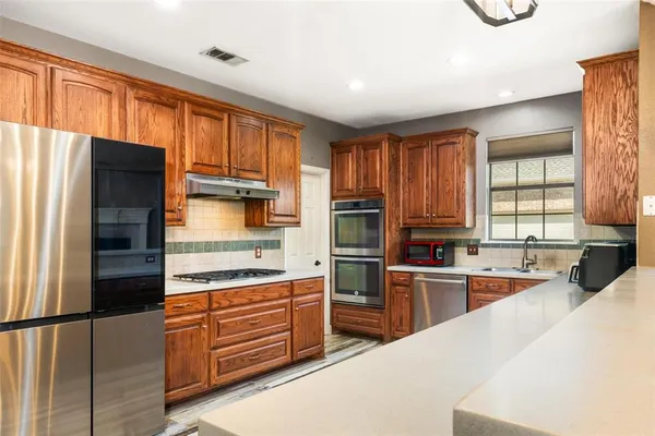 a kitchen with stainless steel appliances a refrigerator sink and cabinets