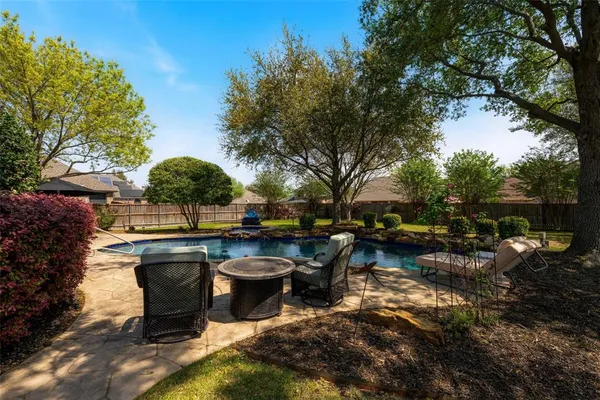 a view of a swimming pool with a bench in the garden
