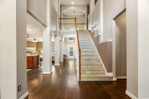 a view of a hallway with wooden floor and staircase