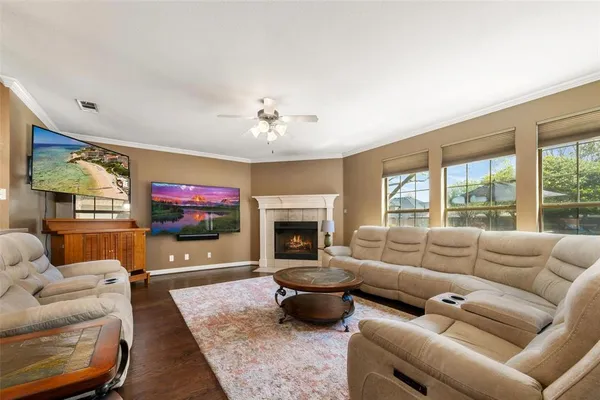 a living room with furniture a flat screen tv and a fireplace