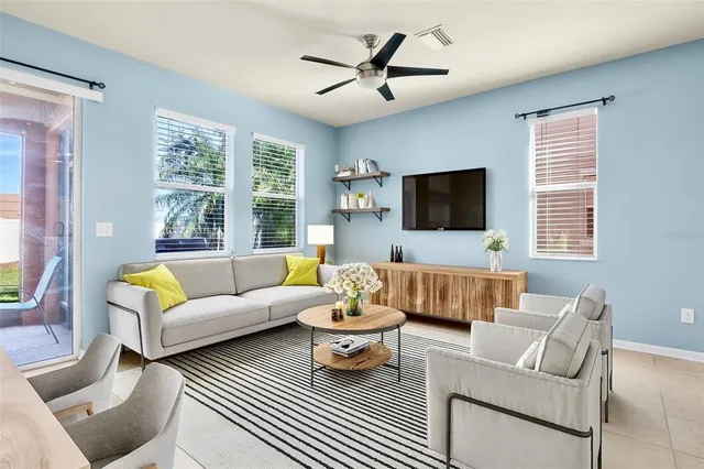 a living room with furniture a flat screen tv and a large window
