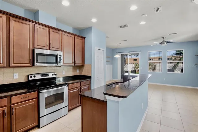 a kitchen with stainless steel appliances granite countertop a stove microwave and sink