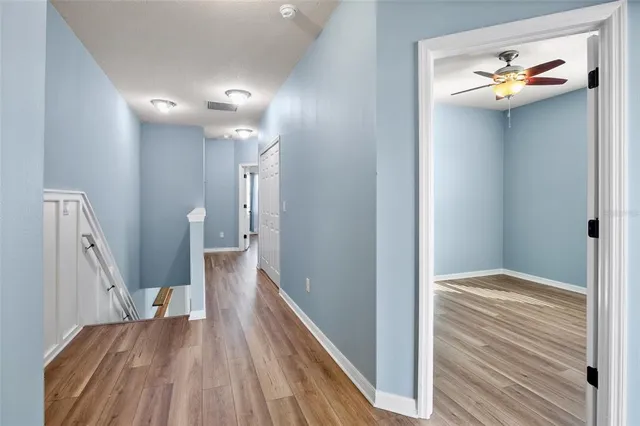 a view of a hallway view with wooden floor and staircase