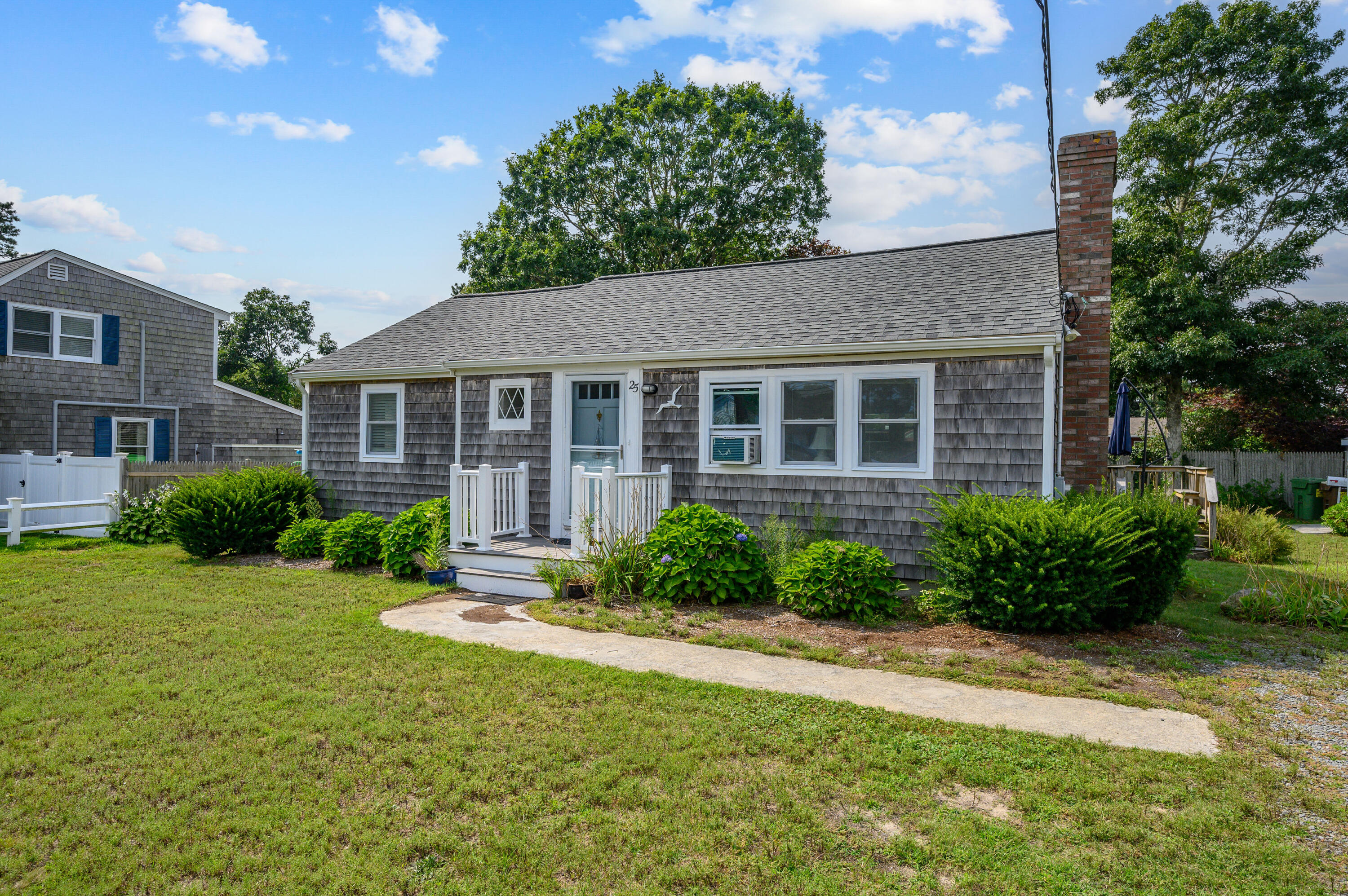 25 Pine Cone Drive West Yarmouth, MA 02673 - Photo 3 of 34 a front view of a house with a yard and outdoor seating