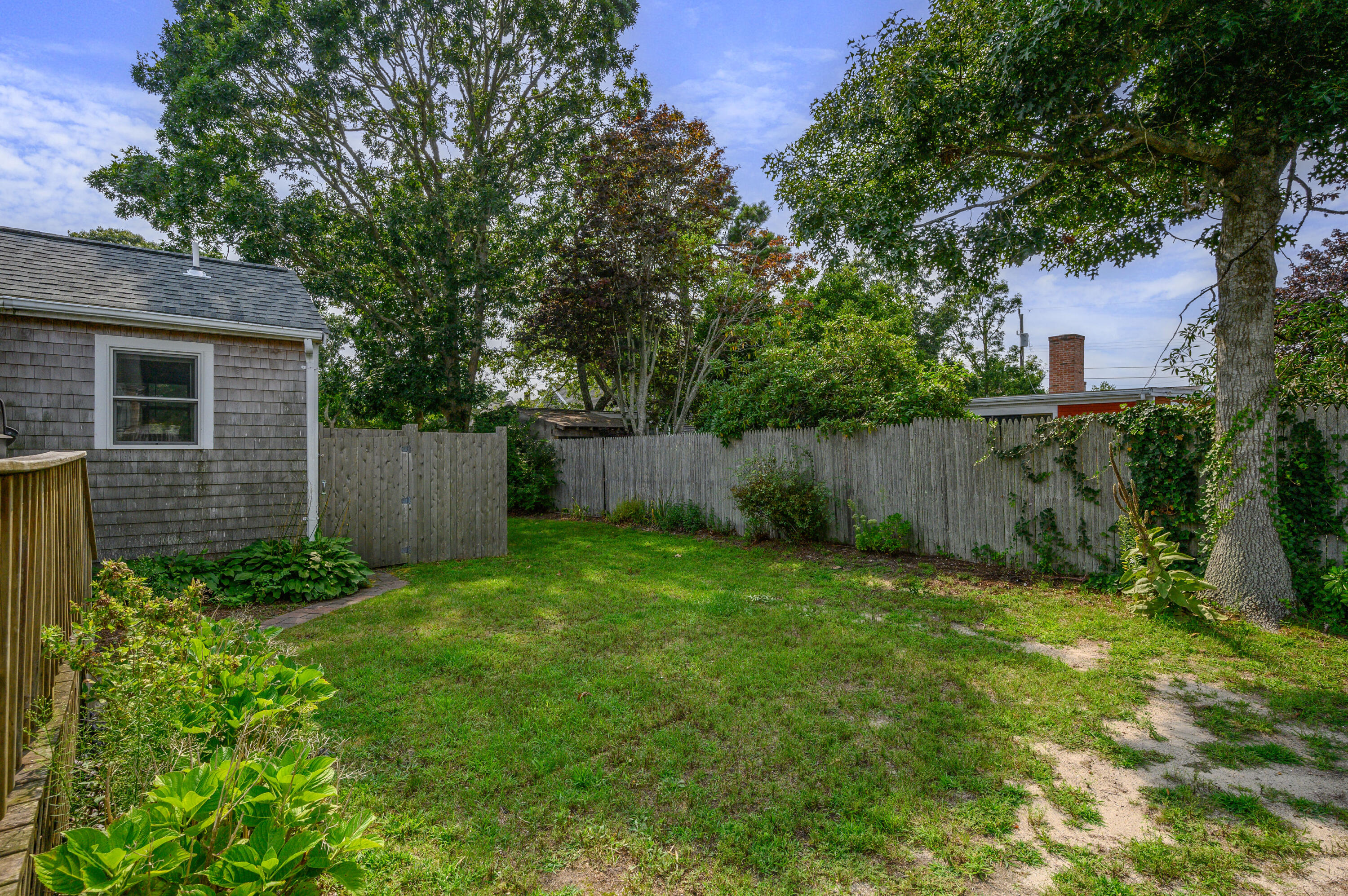 25 Pine Cone Drive West Yarmouth, MA 02673 - Photo 31 of 34 a view of a backyard with a plants and large tree