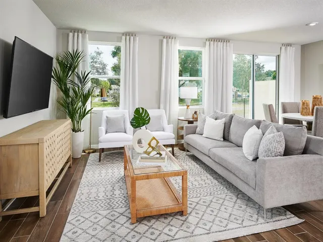 a living room with furniture a flat screen tv and a large window
