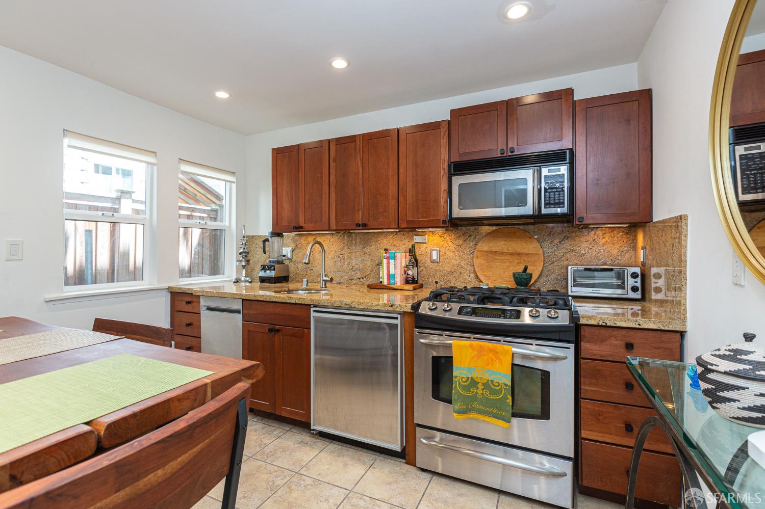 863 Haight Street, Unit 5 San Francisco, CA 94117 - Photo 11 of 16 a kitchen with stainless steel appliances granite countertop a stove a sink and a microwave