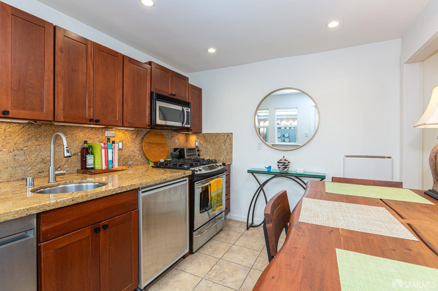 863 Haight Street, Unit 5 San Francisco, CA 94117 - Photo 12 of 16 a kitchen with stainless steel appliances granite countertop a stove a sink and a microwave
