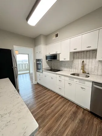a kitchen with granite countertop a stove top oven sink and cabinets