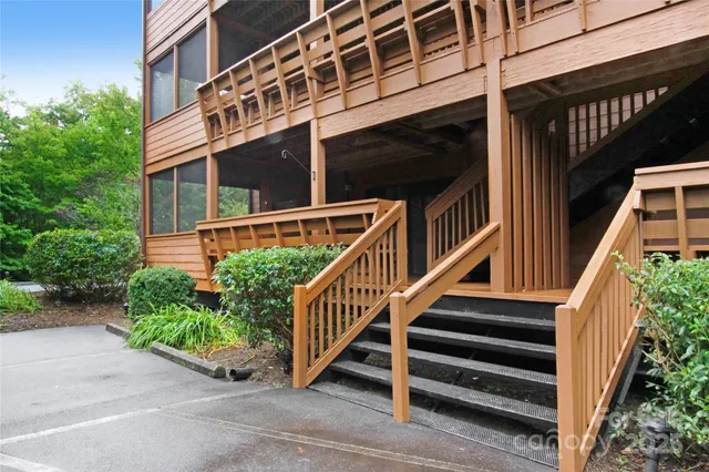 a view of a porch with wooden floor and roof with a garden view