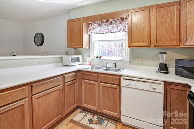 a kitchen with cabinets appliances a sink and a window