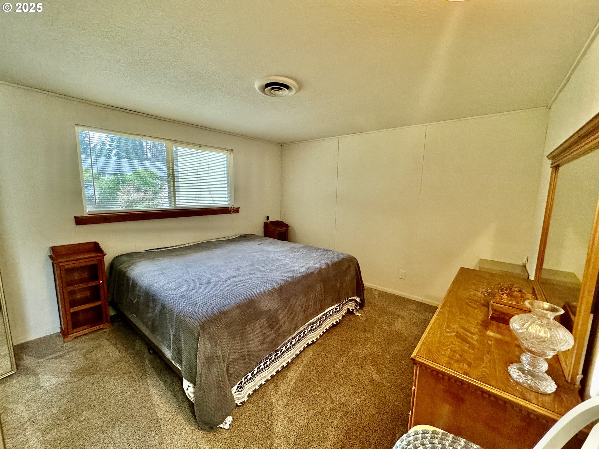 4990 Mitchell Loop Road Florence, OR 97439 - Photo 22 of 37 a bedroom with a bed and a flat screen tv