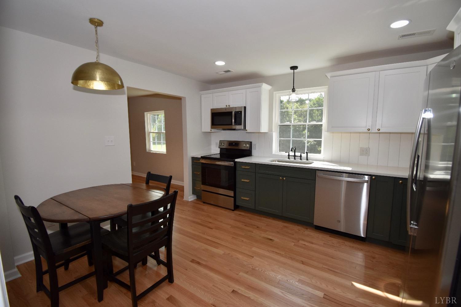 30 Sawmill Road Concord, VA 24538 - Photo 9 of 34 a kitchen with granite countertop a stove a sink a dining table and chairs